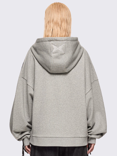 Grey marl zip-up hoodie with black lace corset details along the sleeves and front. Features a drawstring hood, zip fastening, long sleeves, and an oversized fit.