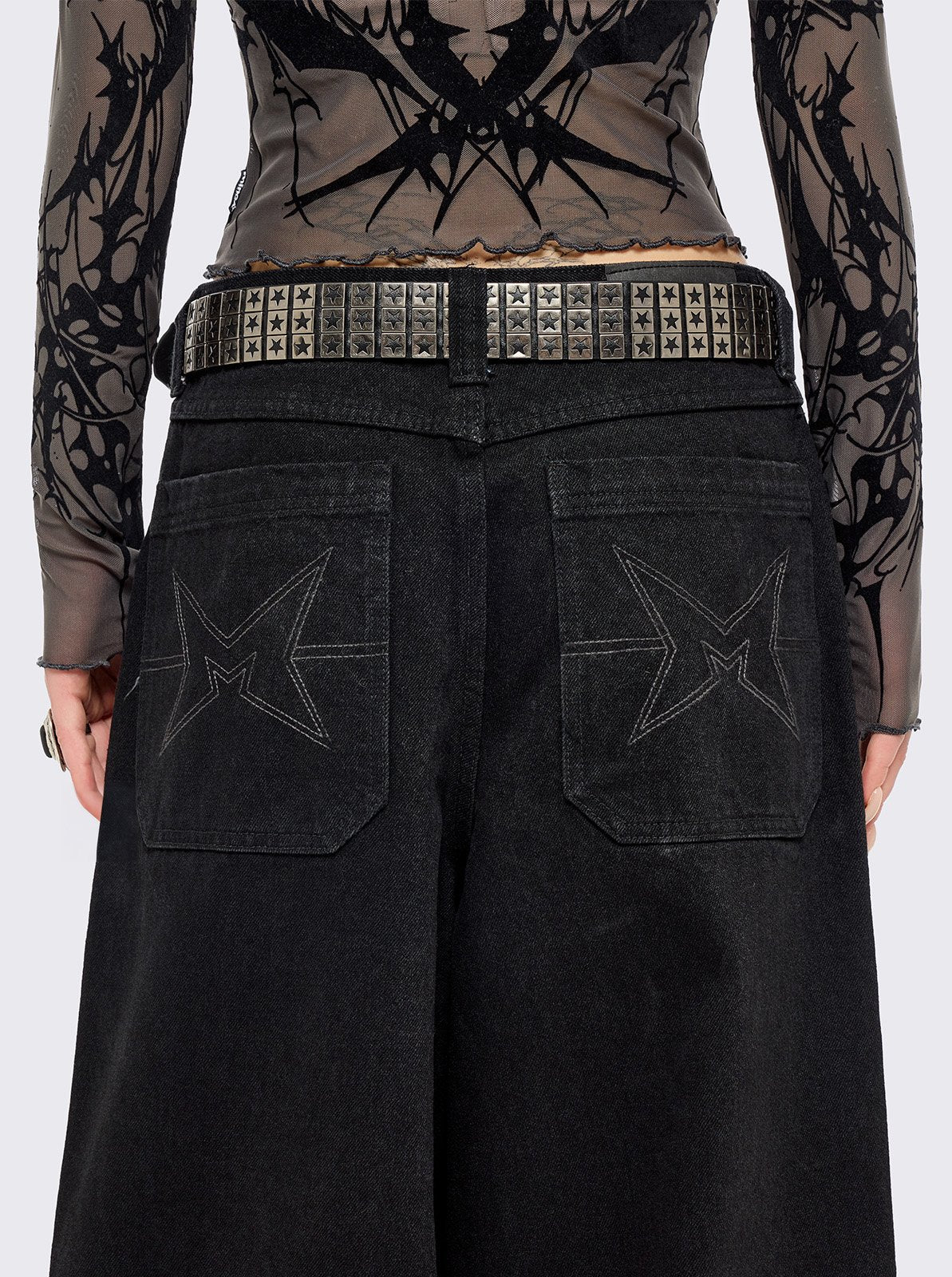 Black vegan leather buckle belt with silver studs in star design. 