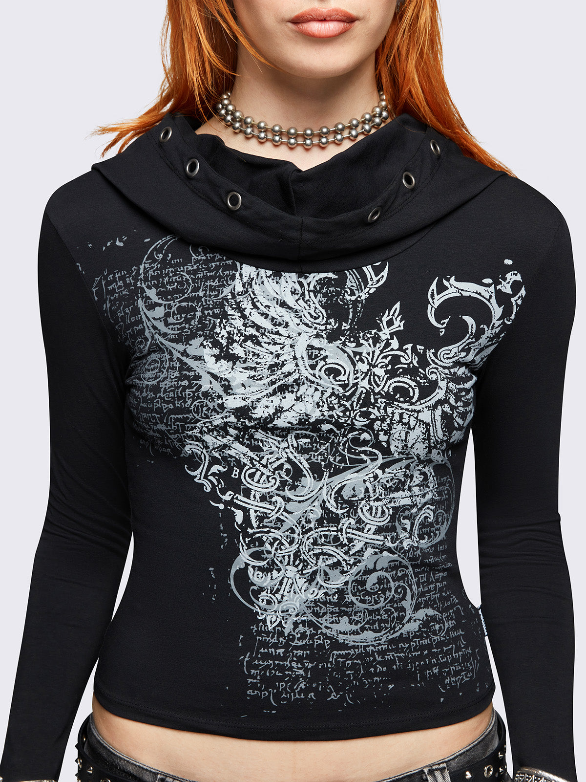 Black hooded top featuring a cowl neck with eyelets details, wings graphic front print and thumbhole cuffs. 