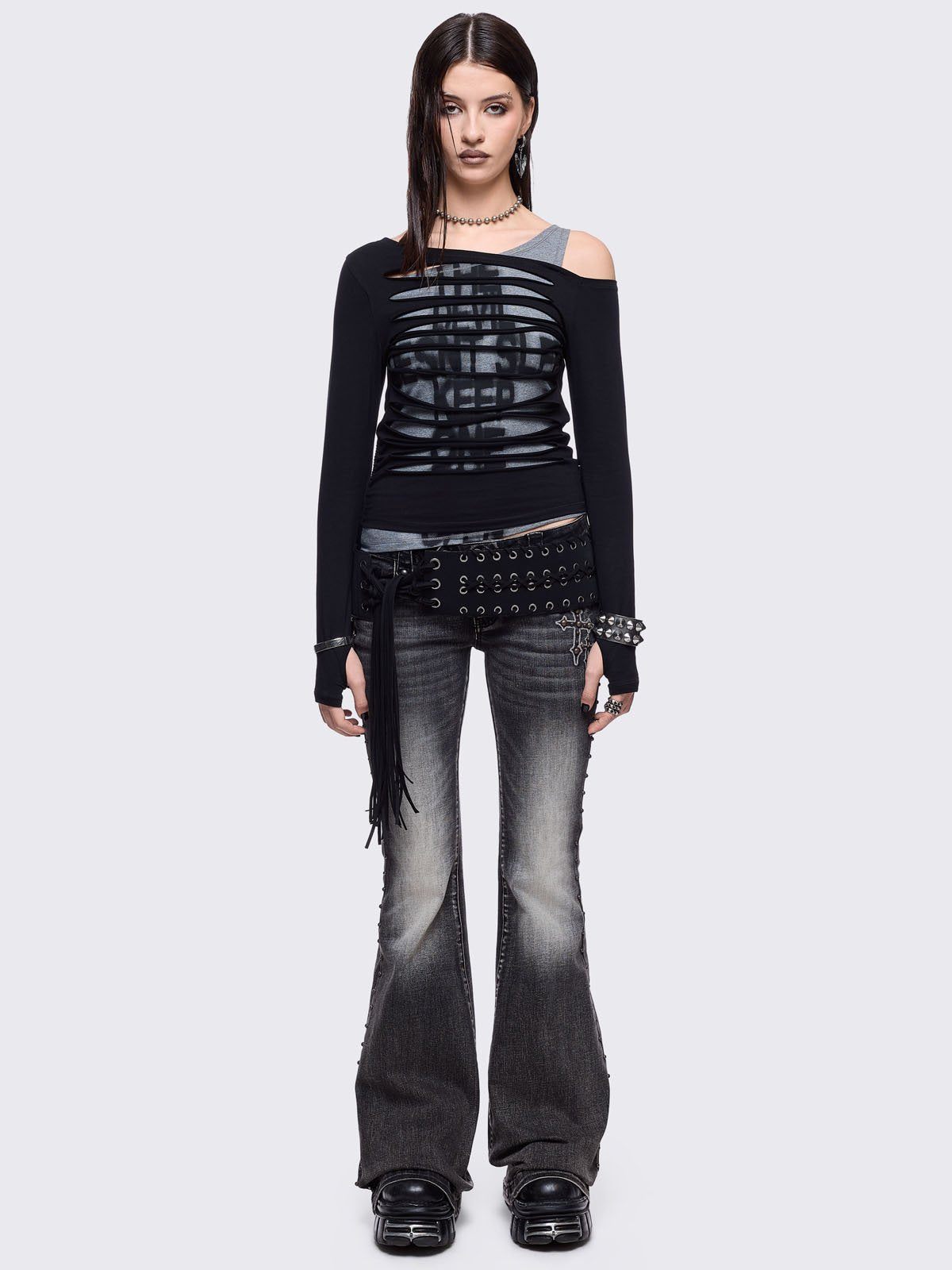 Black and grey long sleeve layered cold shoulder top featuring a front cut-out slash details and a grunge graphic print. 