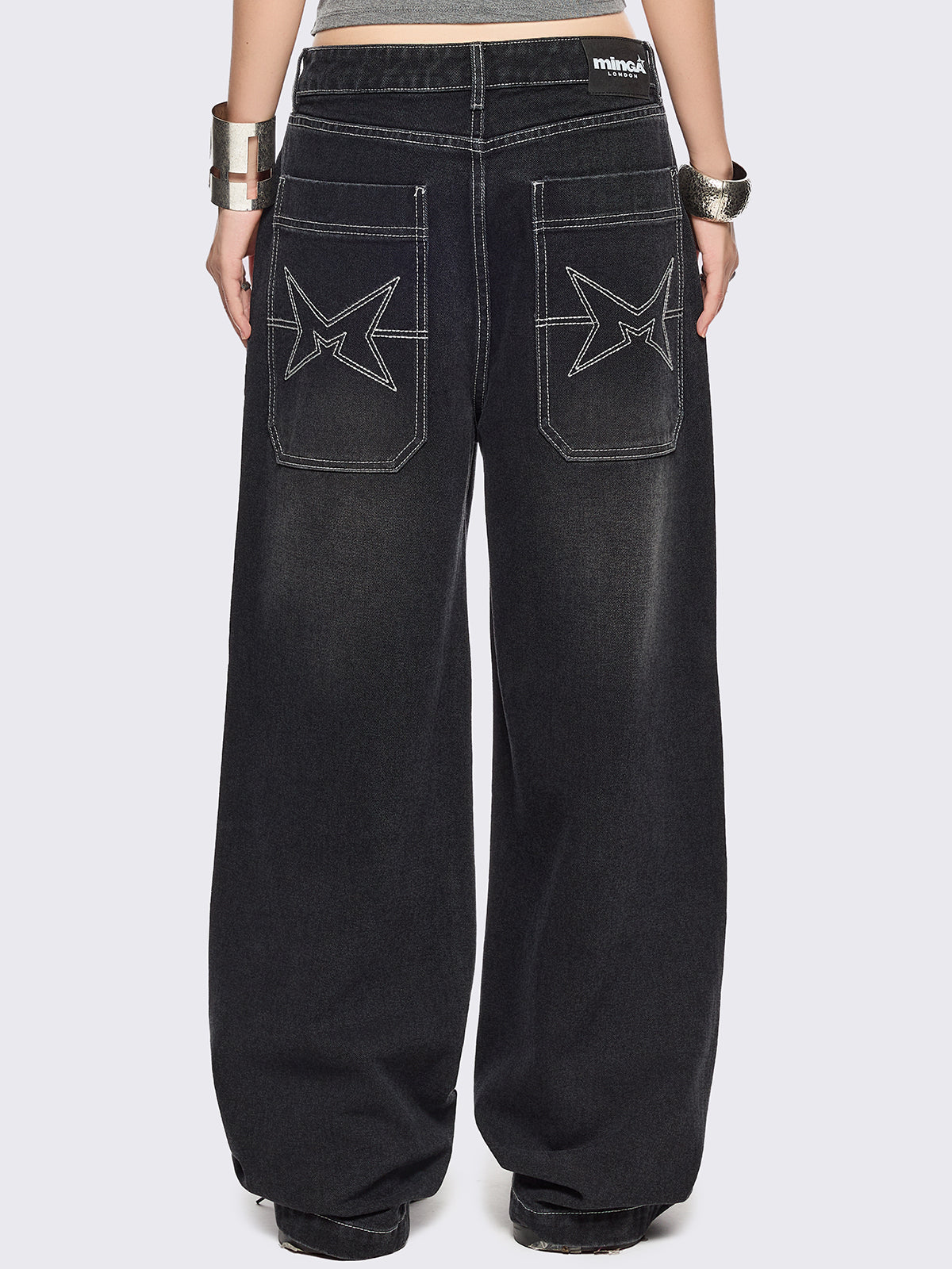 Black baggy wide leg jeans featuring a multi grunge graphic prints with white contrast stitching.