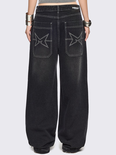 Black baggy wide leg jeans featuring a multi grunge graphic prints with white contrast stitching.