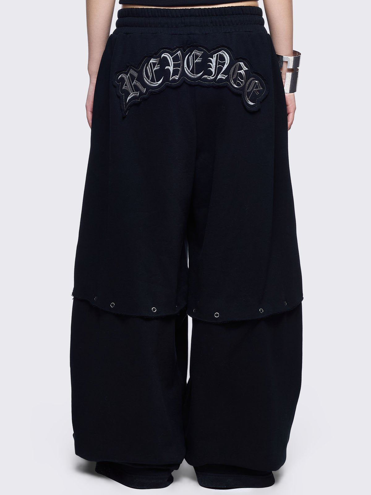 Black sweatpants with silver studded cross, "Reverse" patch back and detachable-leg .