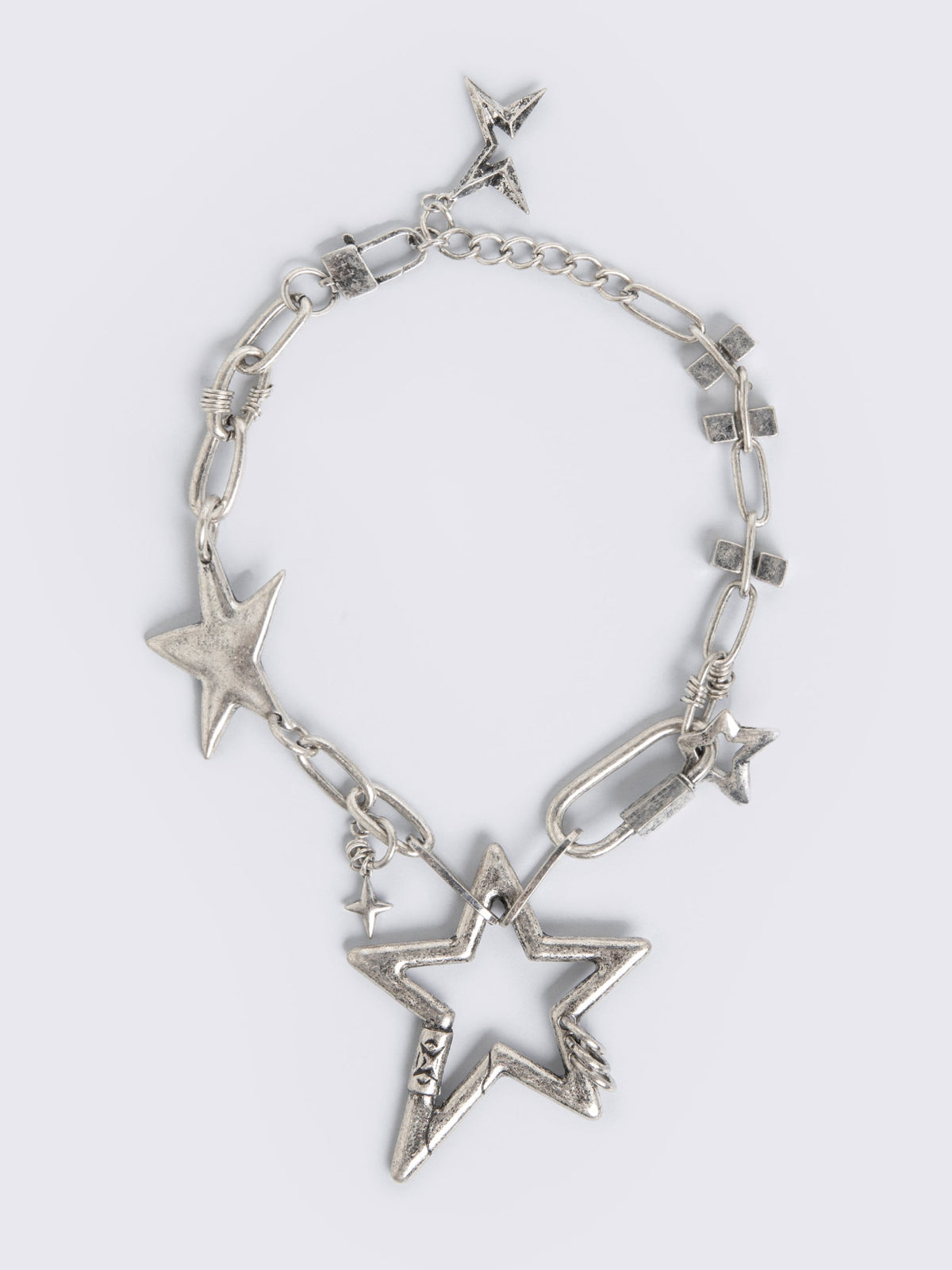 Chunky star charm necklace featuring chain with star and hook details.