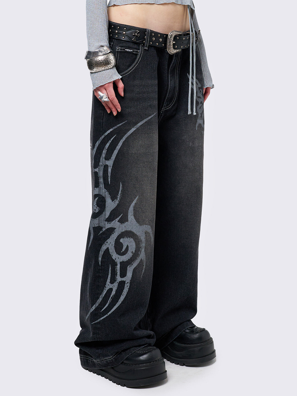 Black washed baggy jeans with a gritty grey sigilism side print, edgy white contrast stitching, regular waist, wide leg, and a relaxed, oversized fit for a grunge-inspired look.