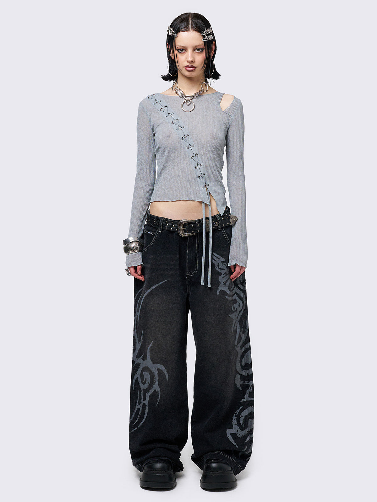 Black washed baggy jeans with a gritty grey sigilism side print, edgy white contrast stitching, regular waist, wide leg, and a relaxed, oversized fit for a grunge-inspired look.