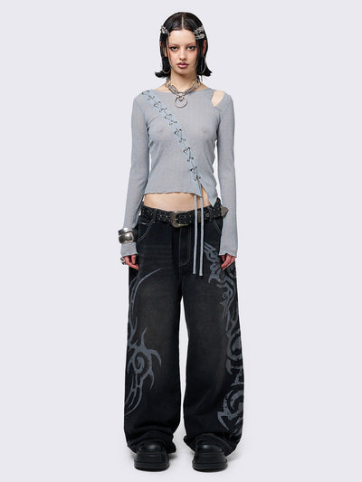 Black washed baggy jeans with a gritty grey sigilism side print, edgy white contrast stitching, regular waist, wide leg, and a relaxed, oversized fit for a grunge-inspired look.