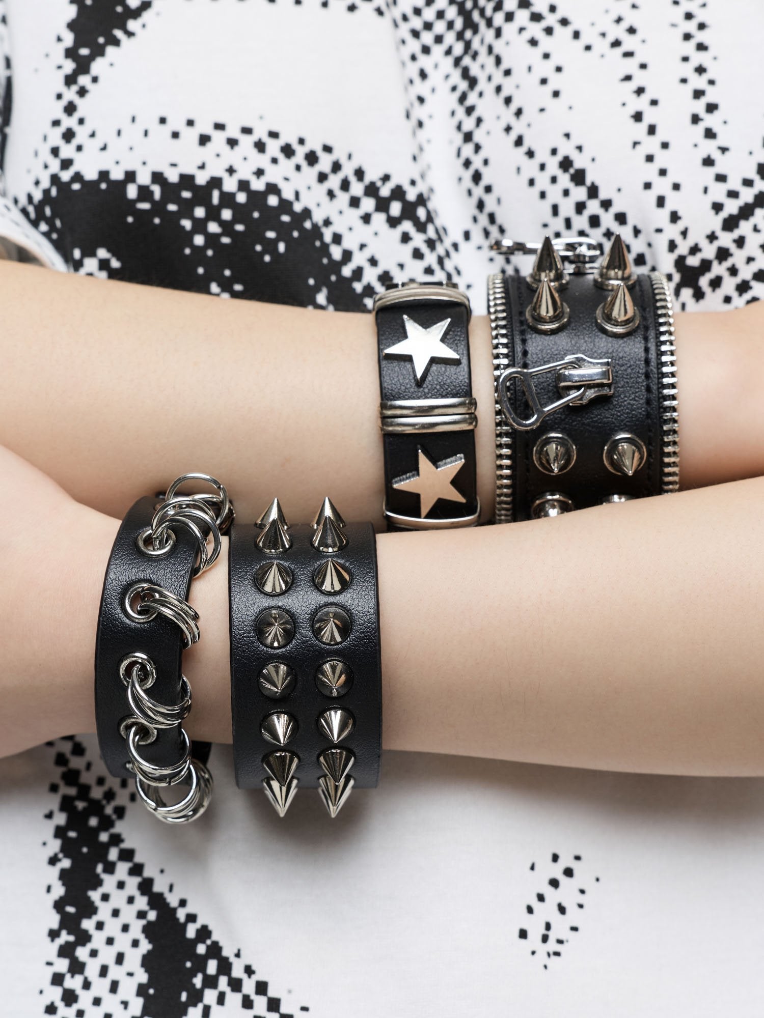 Set of 4 PU bracelets with mix of spikes, stars, zippers and studs. 