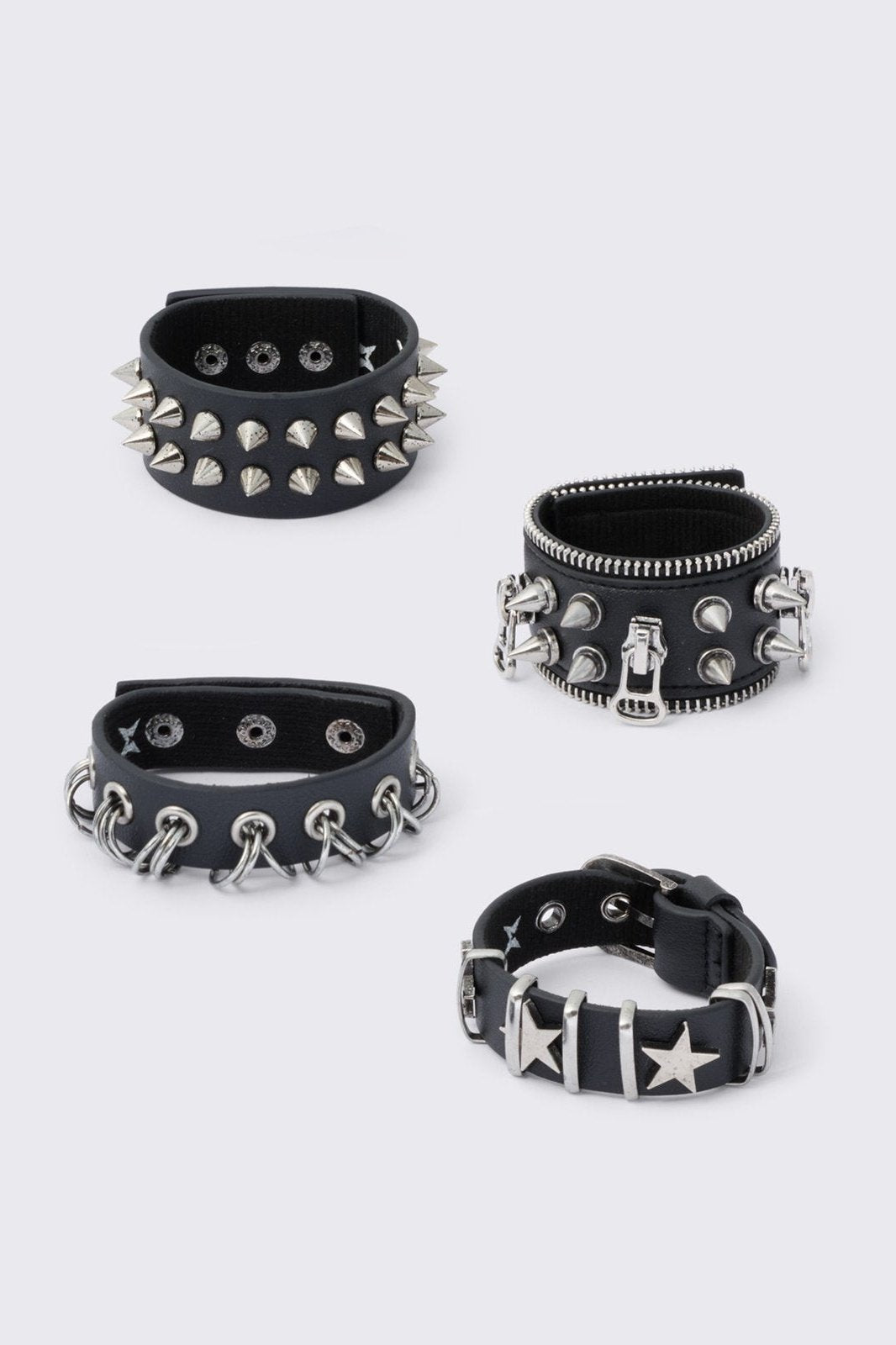 Set of 4 PU bracelets with mix of spikes, stars, zippers and studs. 