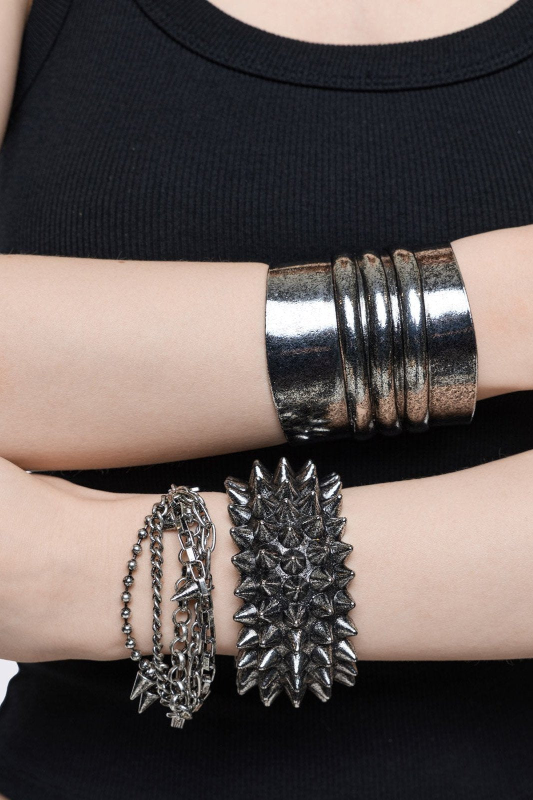 Set of 3 silver bracelets: a wide architectural cuff, a multi-row spike band, and a layered chain bracelet