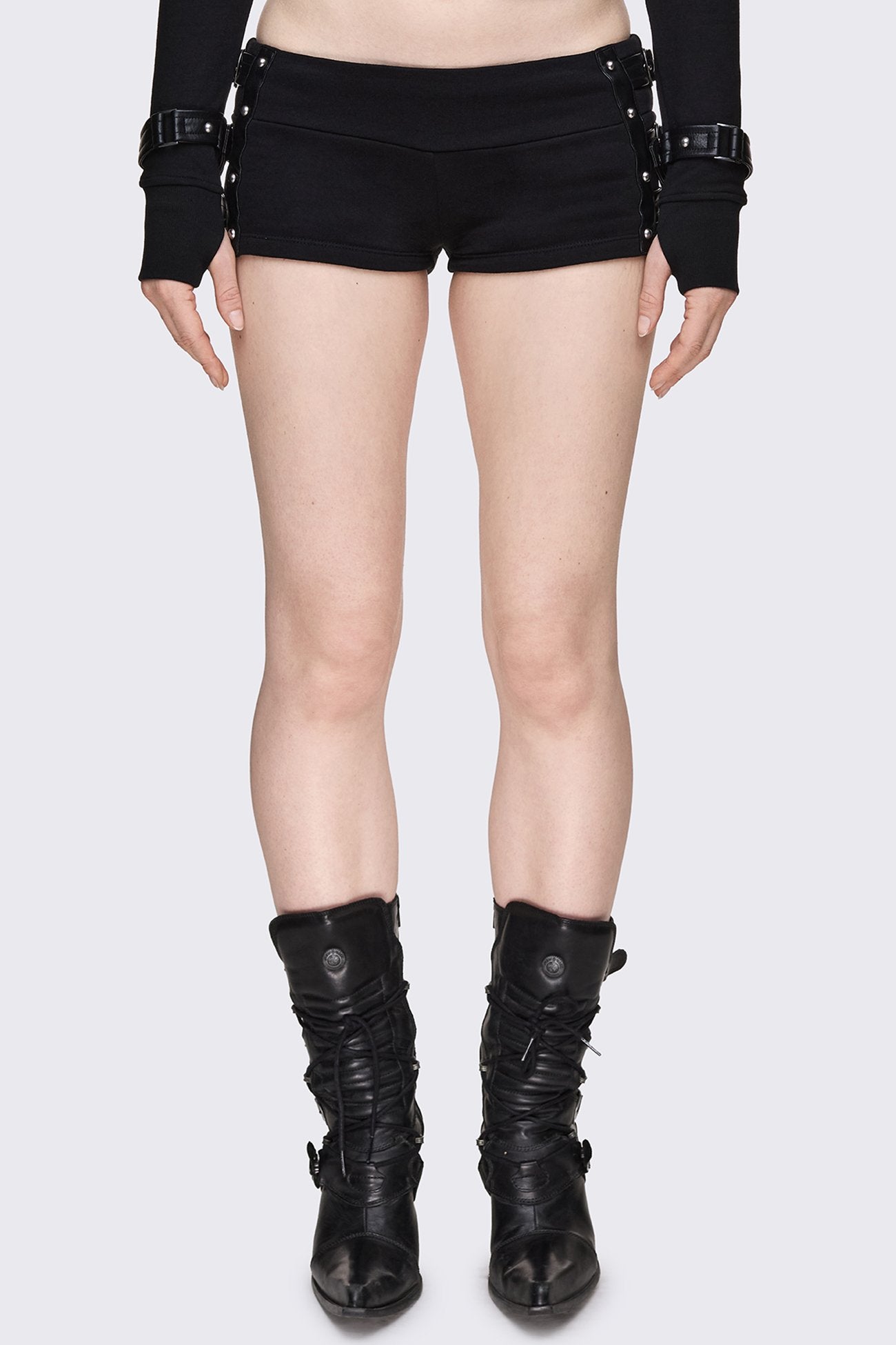 Black low rise micro shorts with faux leather buckle side straps, silver studs and a slim fit.