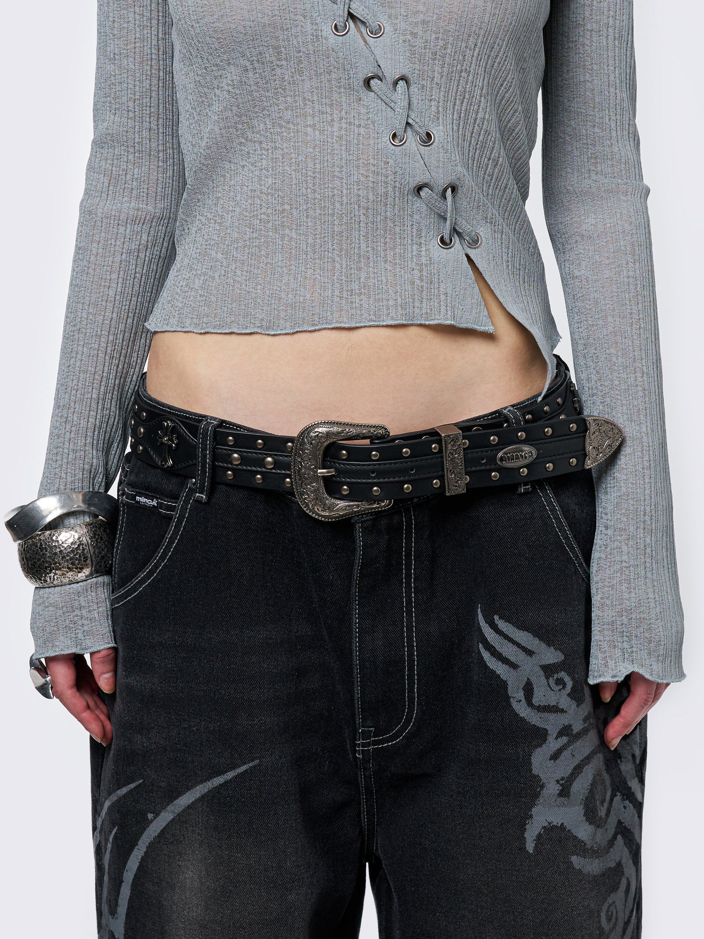 Black studded belt with an antique silver western-style buckle.