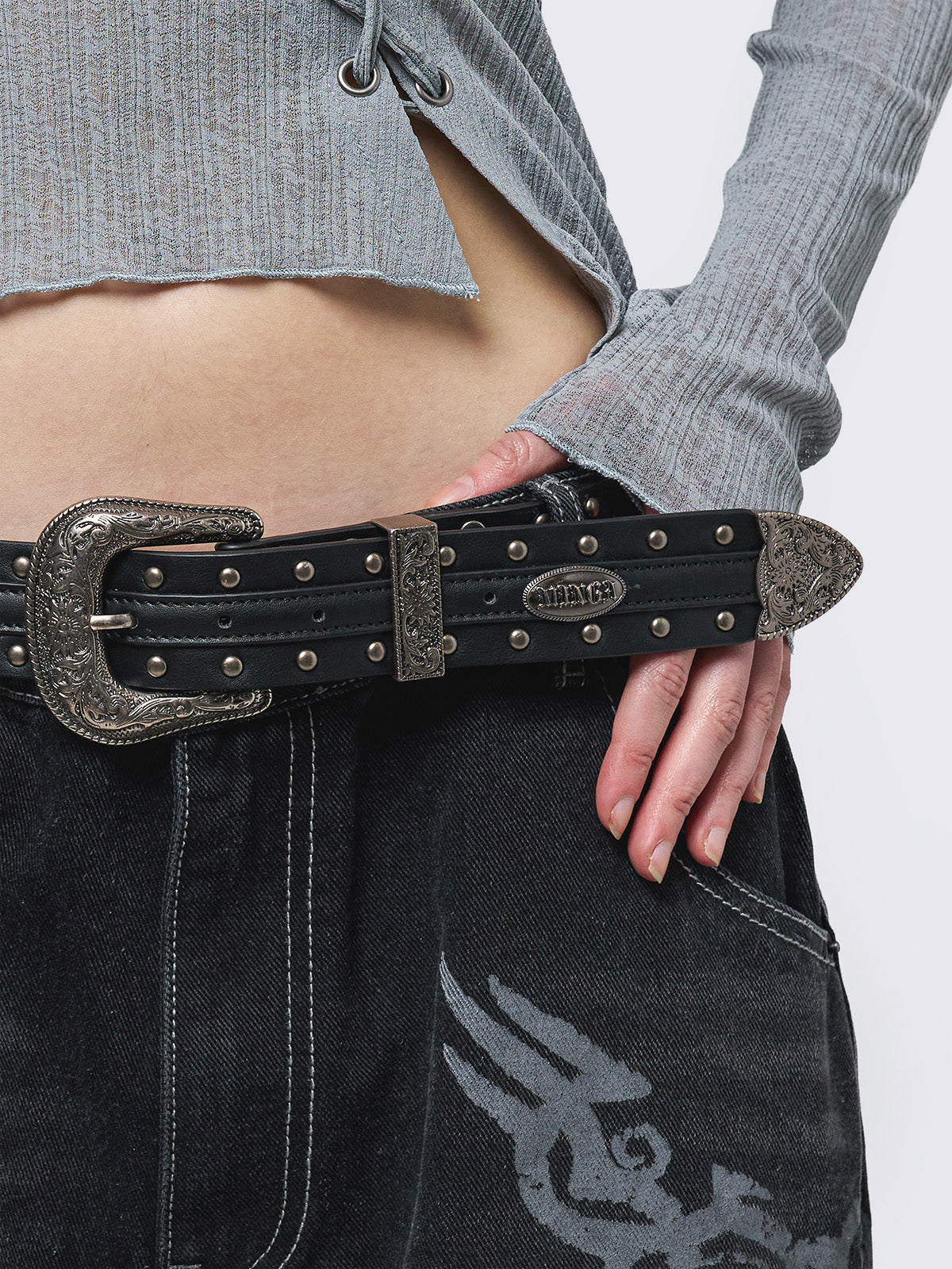 Black studded belt with an antique silver western-style buckle.