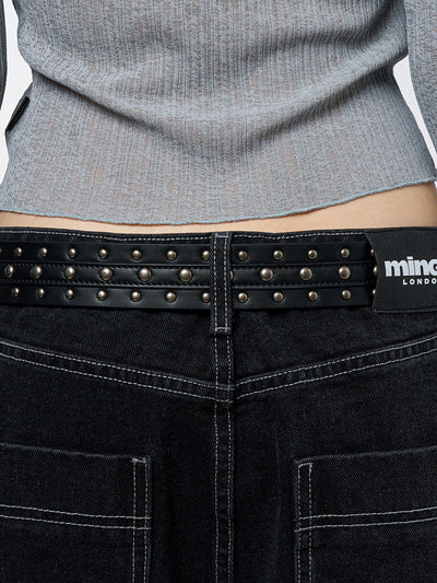 Black studded belt with an antique silver western-style buckle.