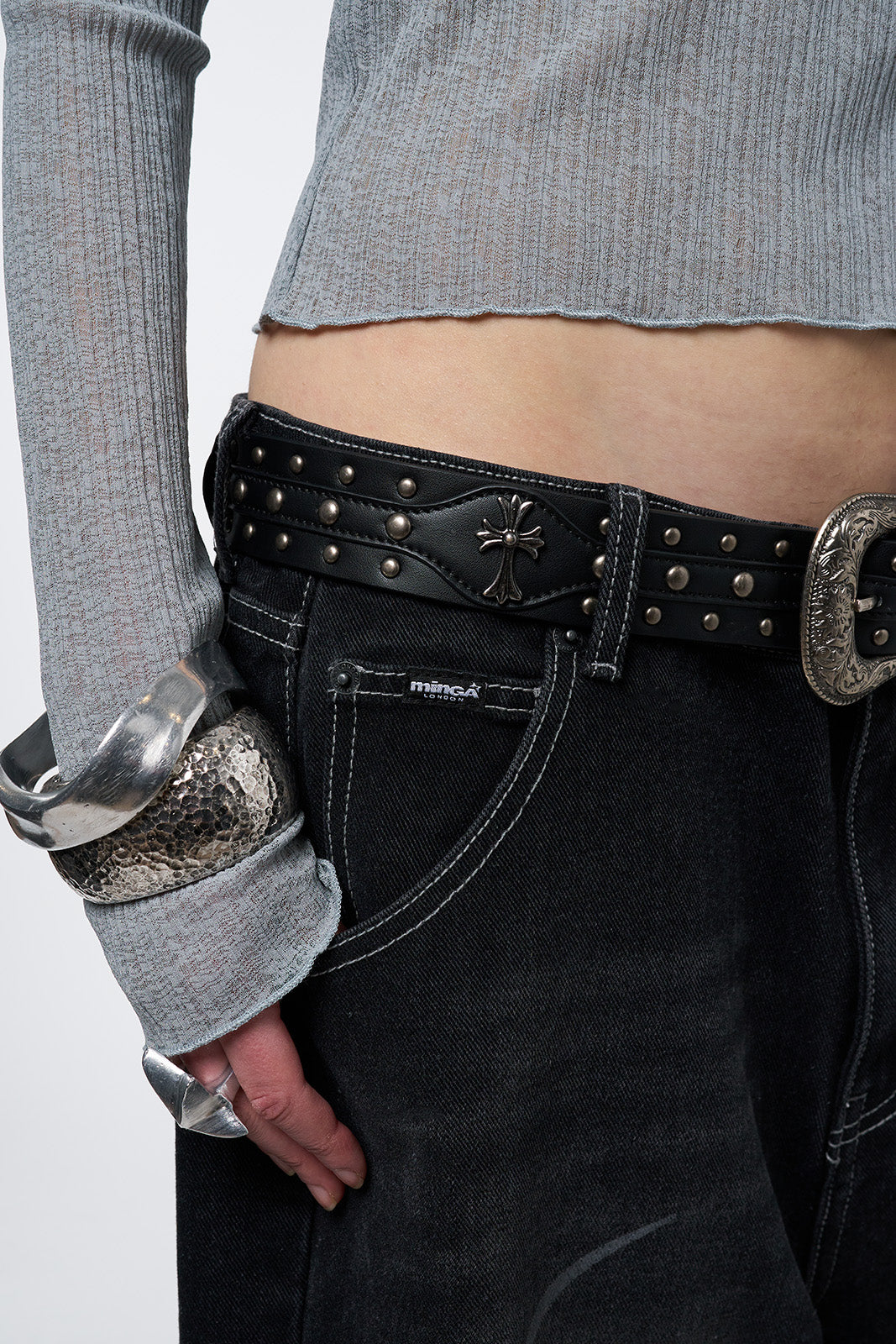 Black studded belt with an antique silver western-style buckle.