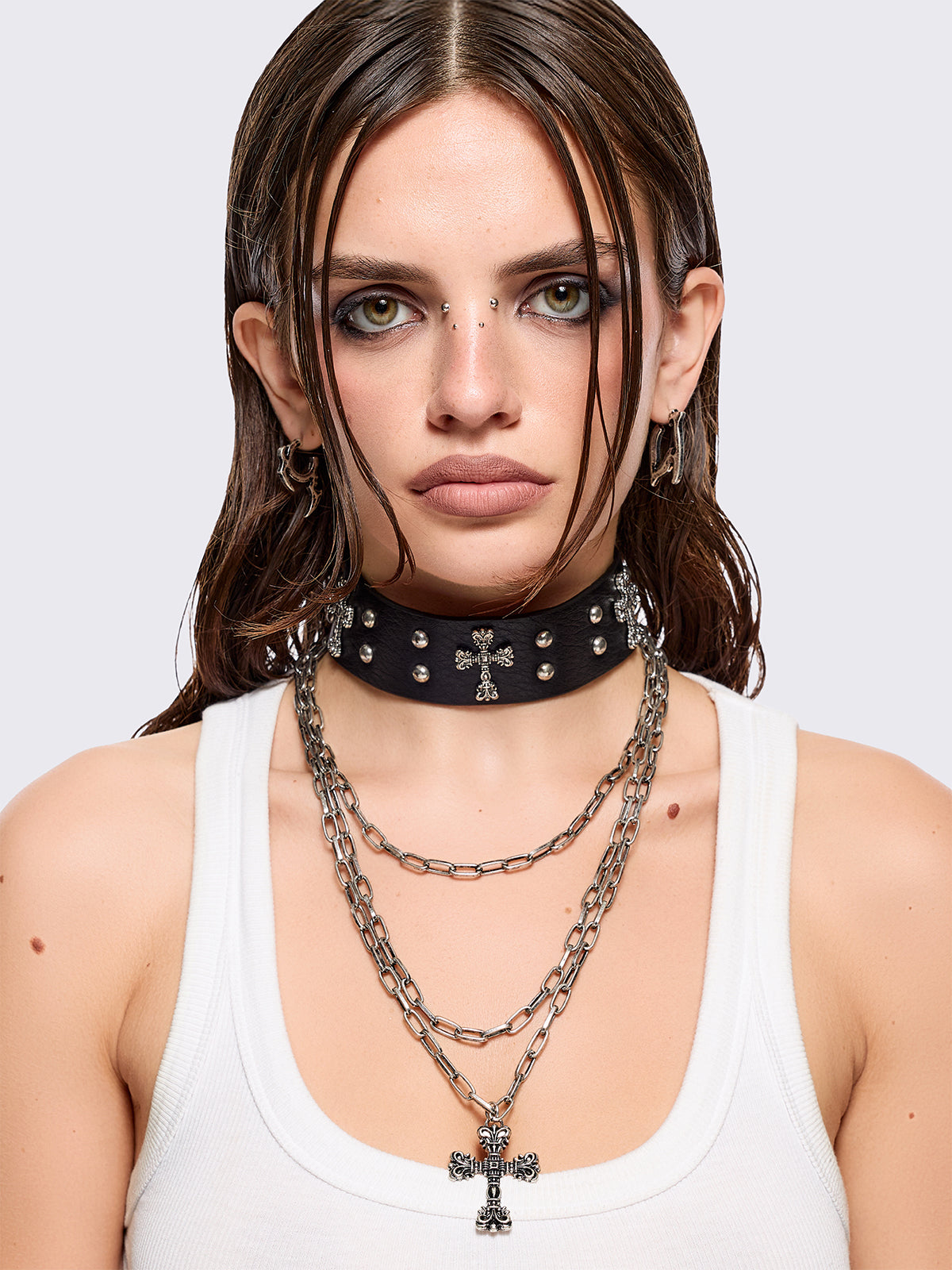 Set of 2 necklaces: One black PU choker with crosses and studs and other silver multiple chain with cross pendant.