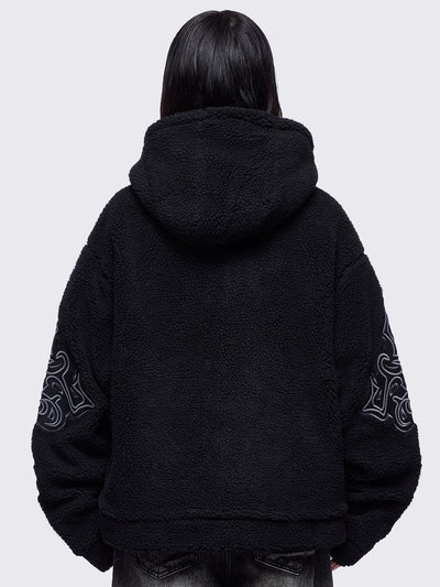 Black fleece hoodie jacket featuring a cross patch on front and sleeves and silver stud details.