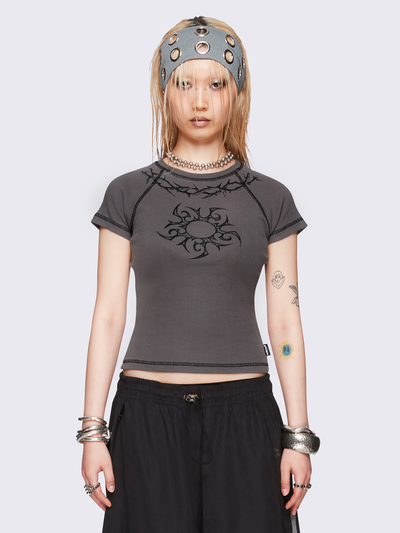 Grey graphic baby tee with tribal sun and thorns print and black contrast stitching.