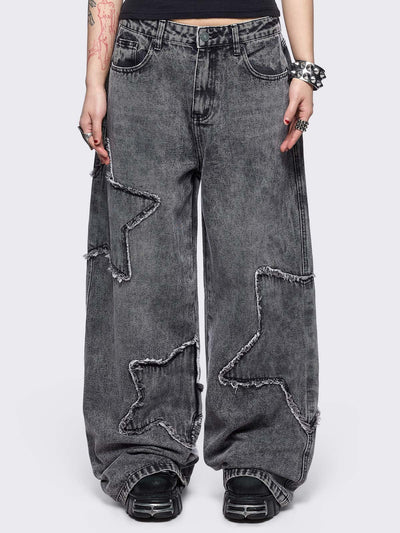 Grey washed baggy jeans with frayed star patches.