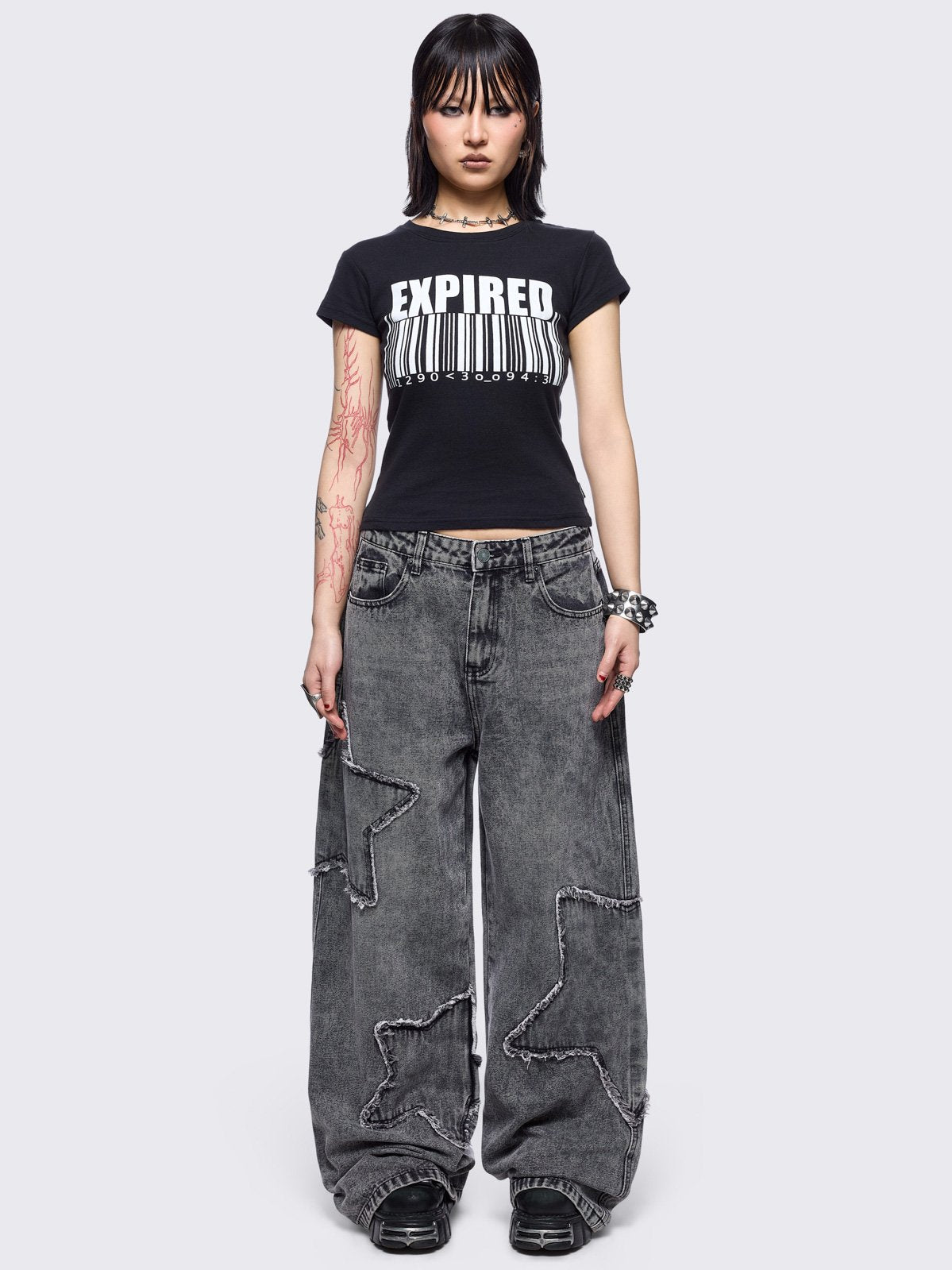 Grey washed baggy jeans with frayed star patches.