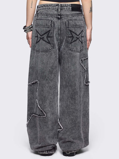 Grey washed baggy jeans with frayed star patches.