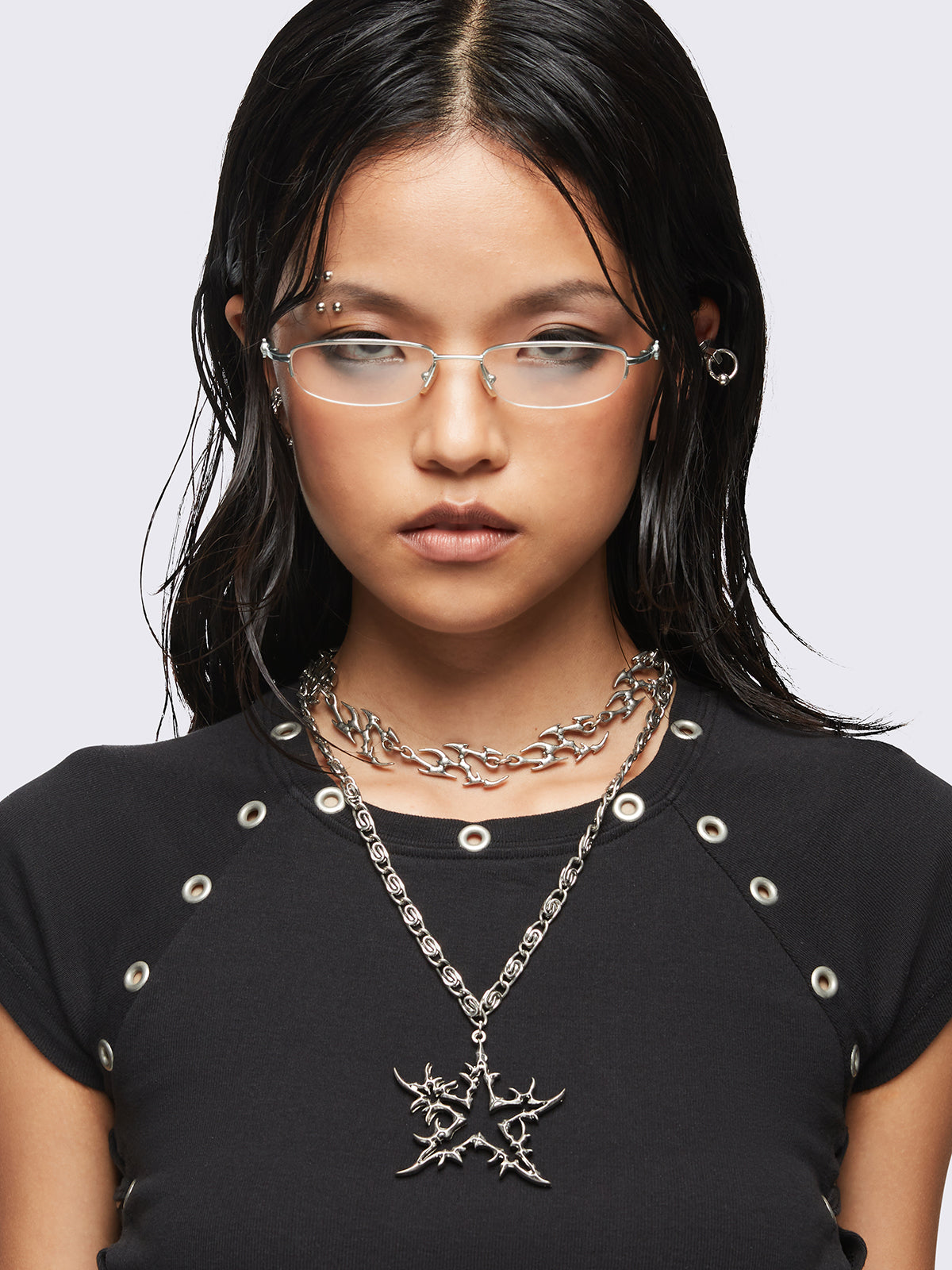 Set of 2 silver necklaces: A chunky chain with multiple sigilism charms and other with a star pendant.