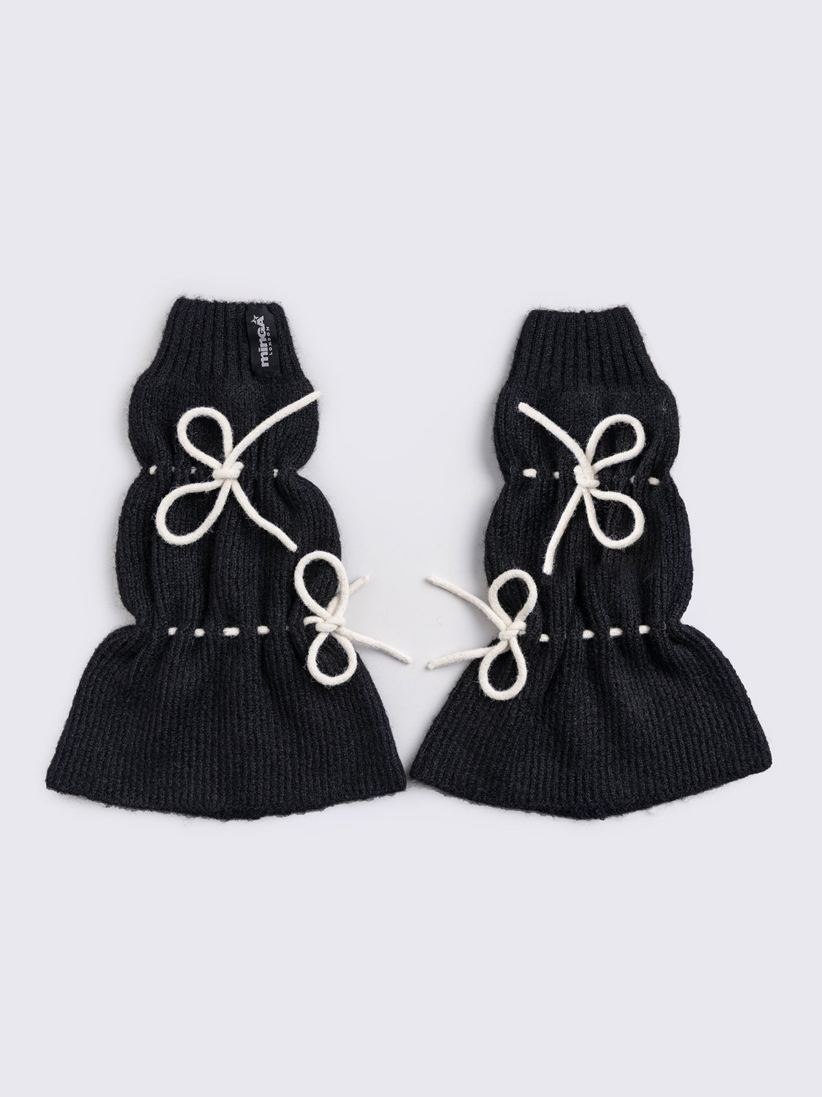 Black knitted leg warmers with white tie bows and a flared style.