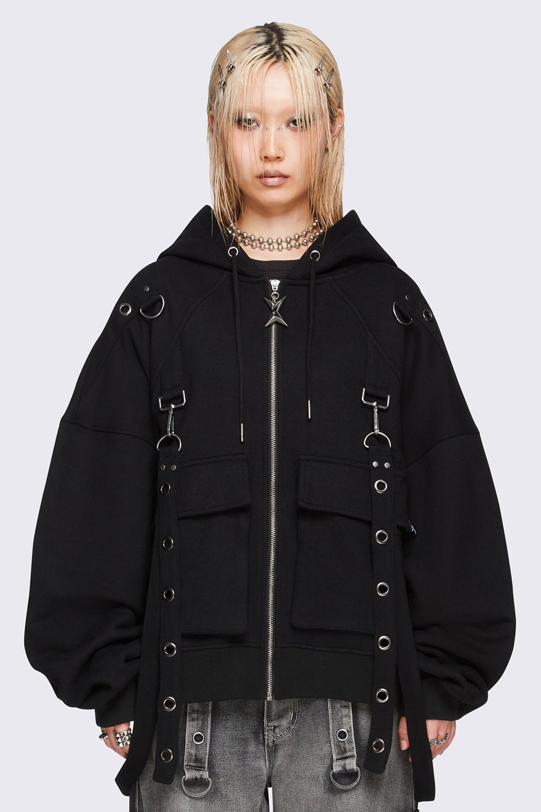 Black oversized zip-up hoodie jacket with straps, metal hardware, and flap pockets.