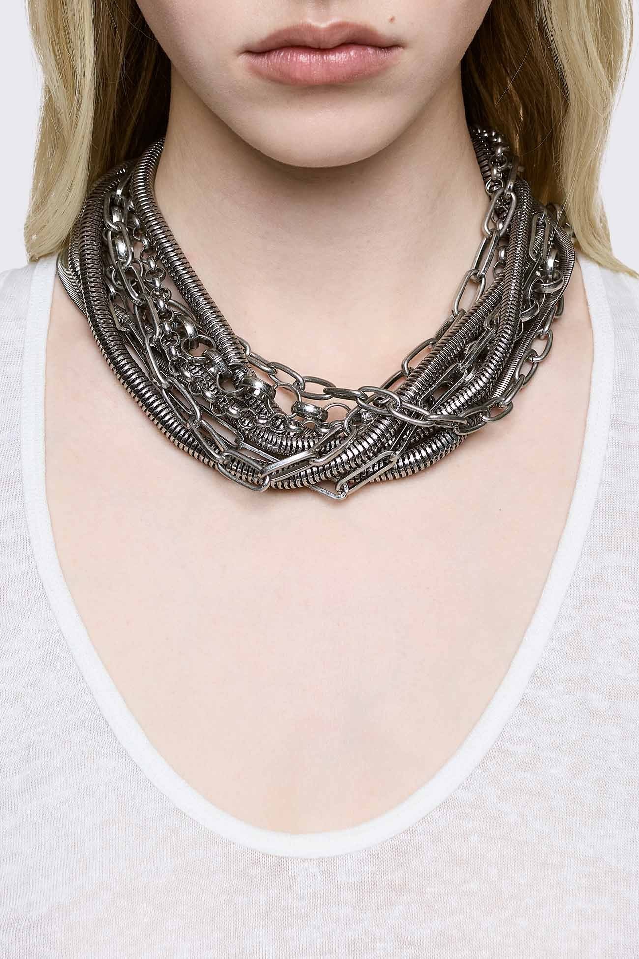 Chunky layered necklace in antique-silver metal with mixed chain textures, grunge aesthetic.