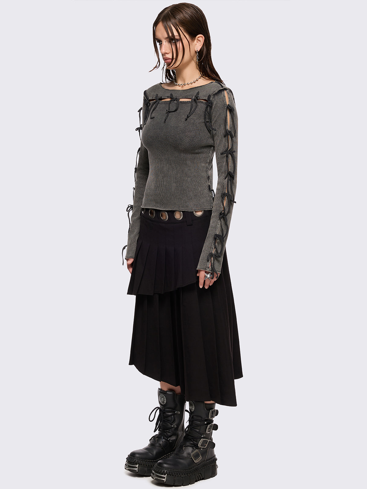 Black pleated asymmetric midi skirt with silver eyelet on waistband