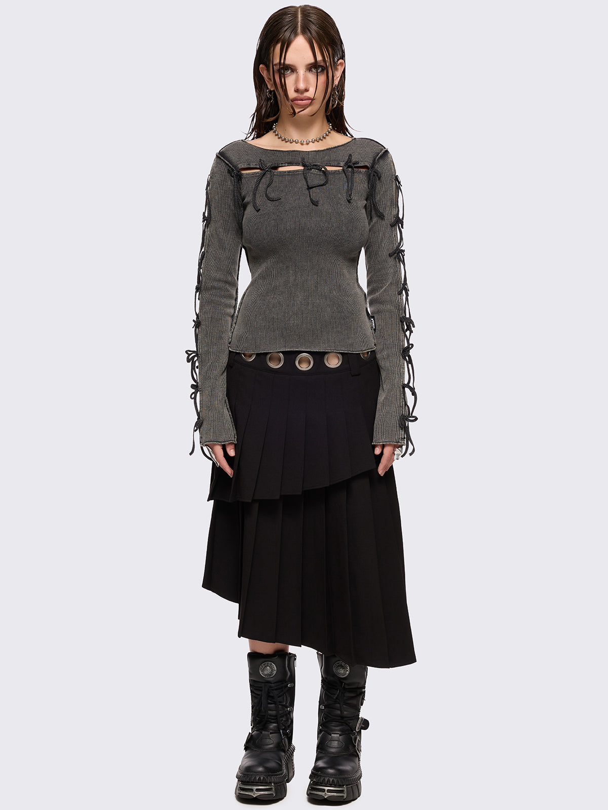 Black pleated asymmetric midi skirt with silver eyelet on waistband