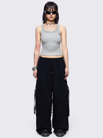 Black wide leg sweatpants featuring moto pintuck panels and lace-up details. 