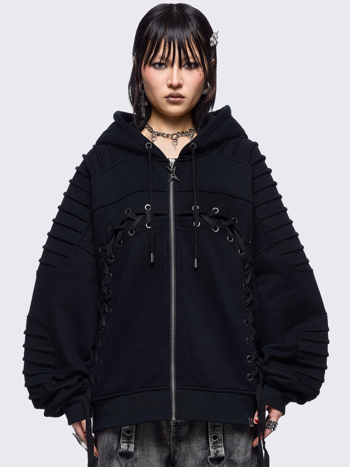 Black zip up hoodie jacket featuring a moto pintuck panels and front lace corset details. 