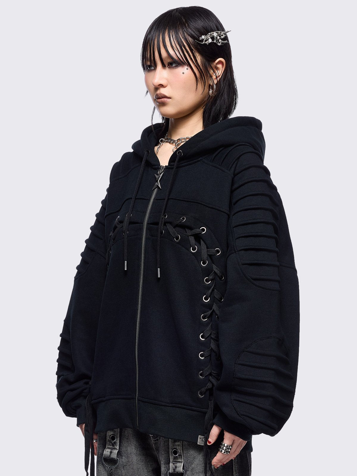Black zip up hoodie jacket featuring a moto pintuck panels and front lace corset details. 