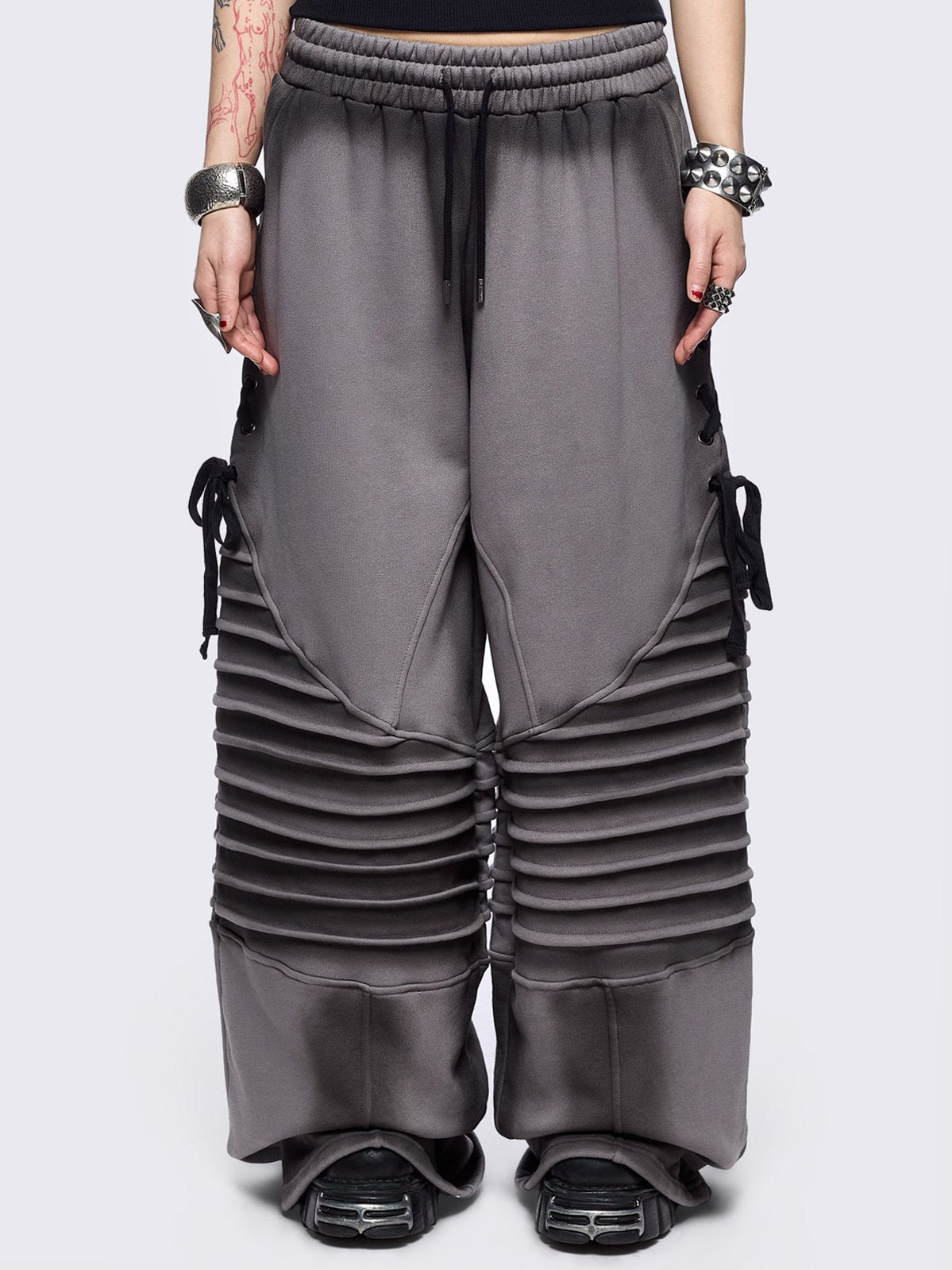 Grey washed wide leg sweatpants featuring moto pintuck panels, lace-up details and black fade out.