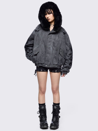 Grey washed denim bomber jacket featuring black sigilism patches and black faux fur hood.