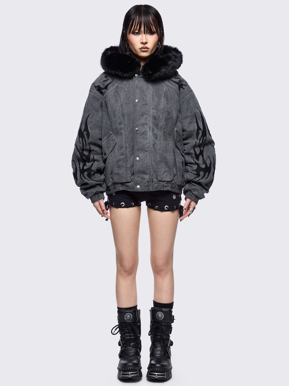 Grey washed denim bomber jacket featuring black sigilism patches and black faux fur hood.