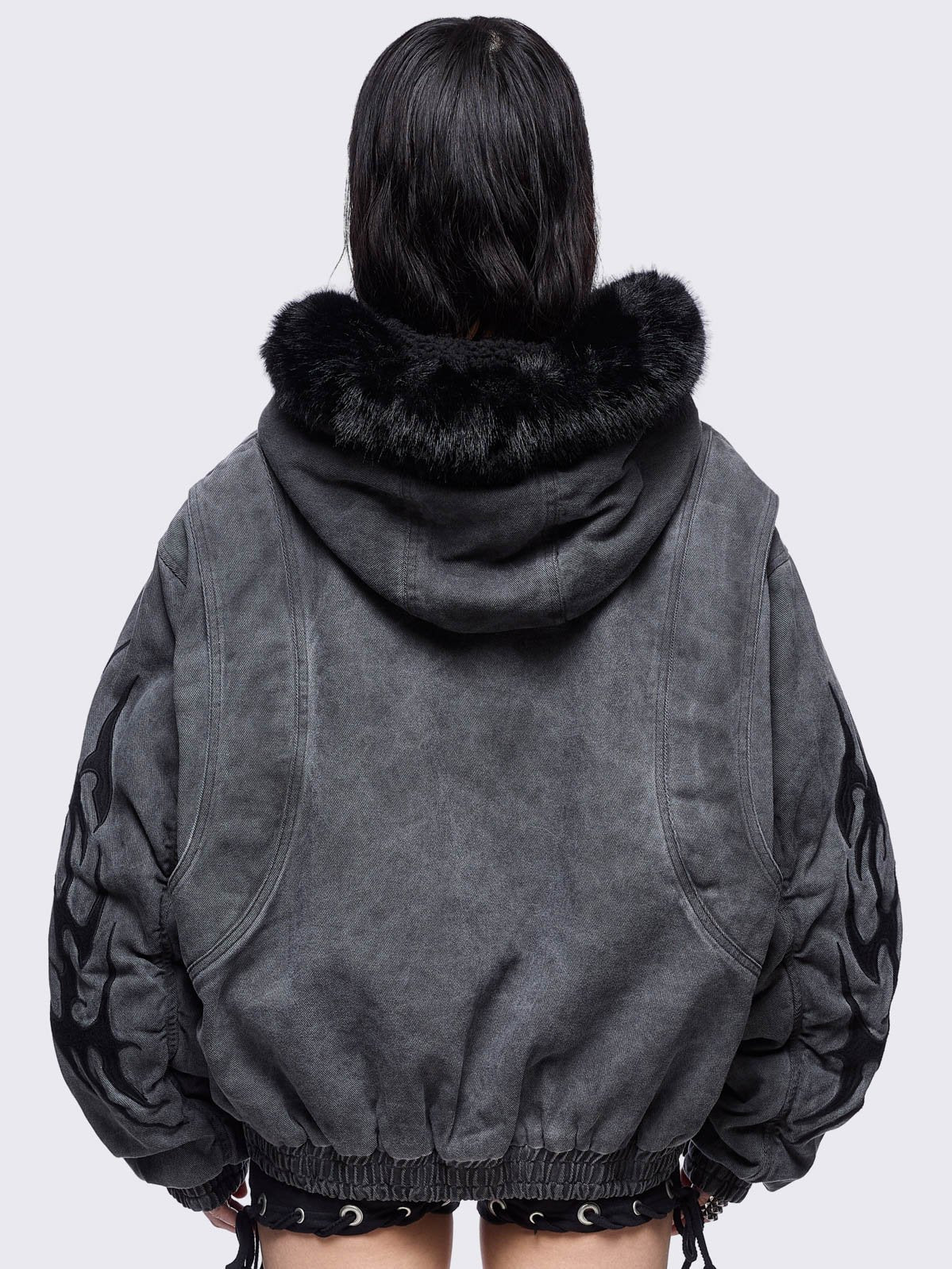 Grey washed denim bomber jacket featuring black sigilism patches and black faux fur hood.