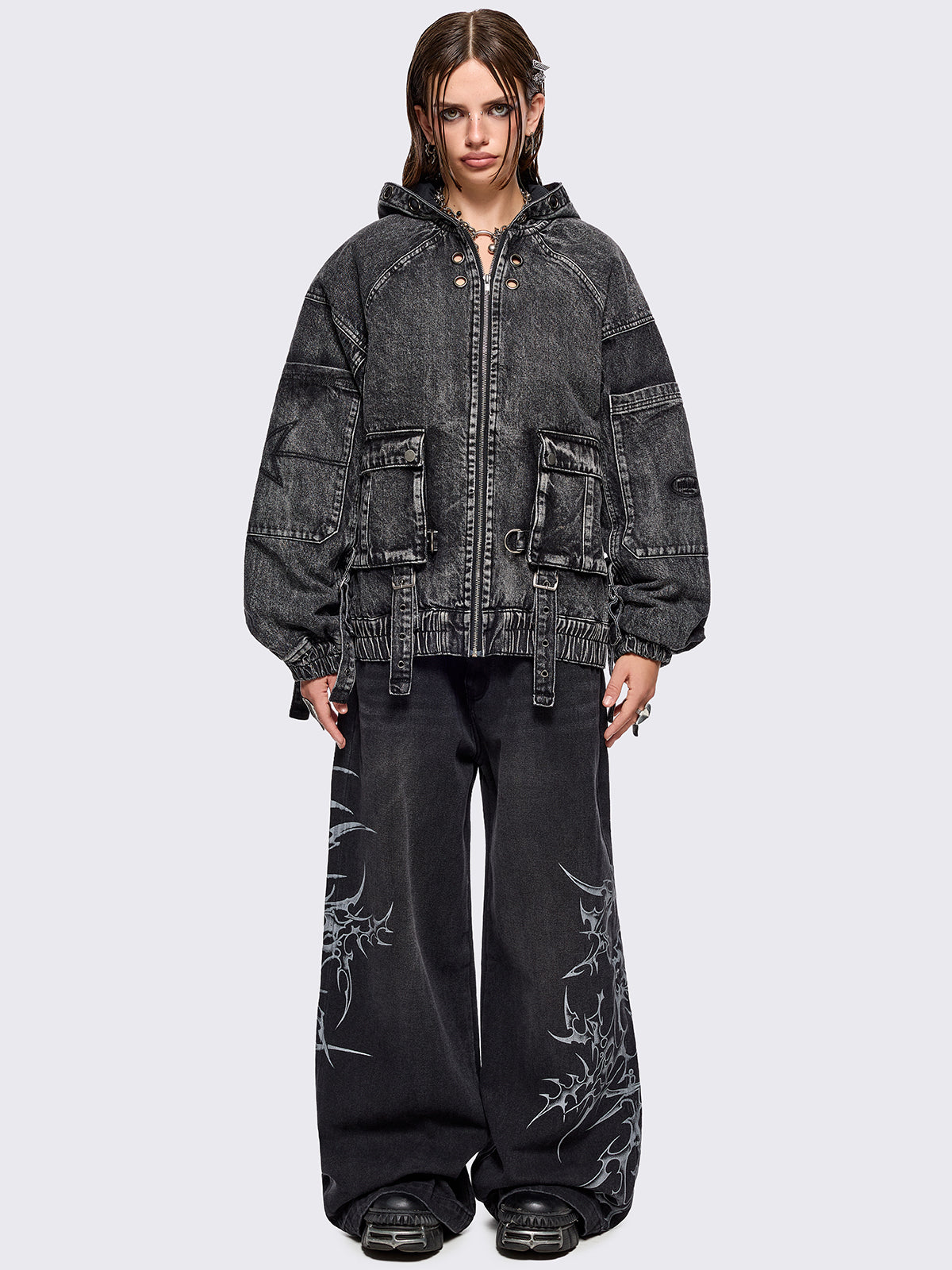 Black acid washed denim bomber jacket featuring boxy oversized fit, front flap pockets, buckle straps, eyelets, metal hardware and seams details.