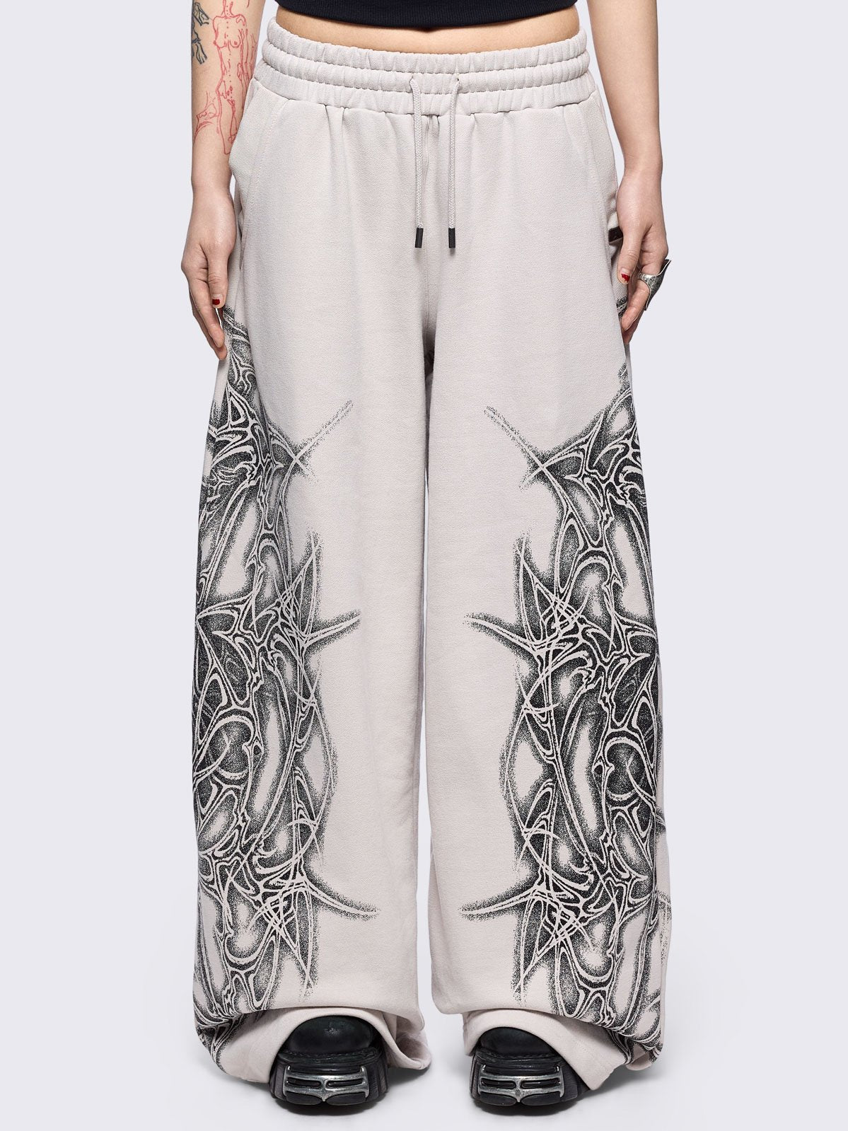Grey wide leg sweatpants featuring a black sigilism graphic side print.