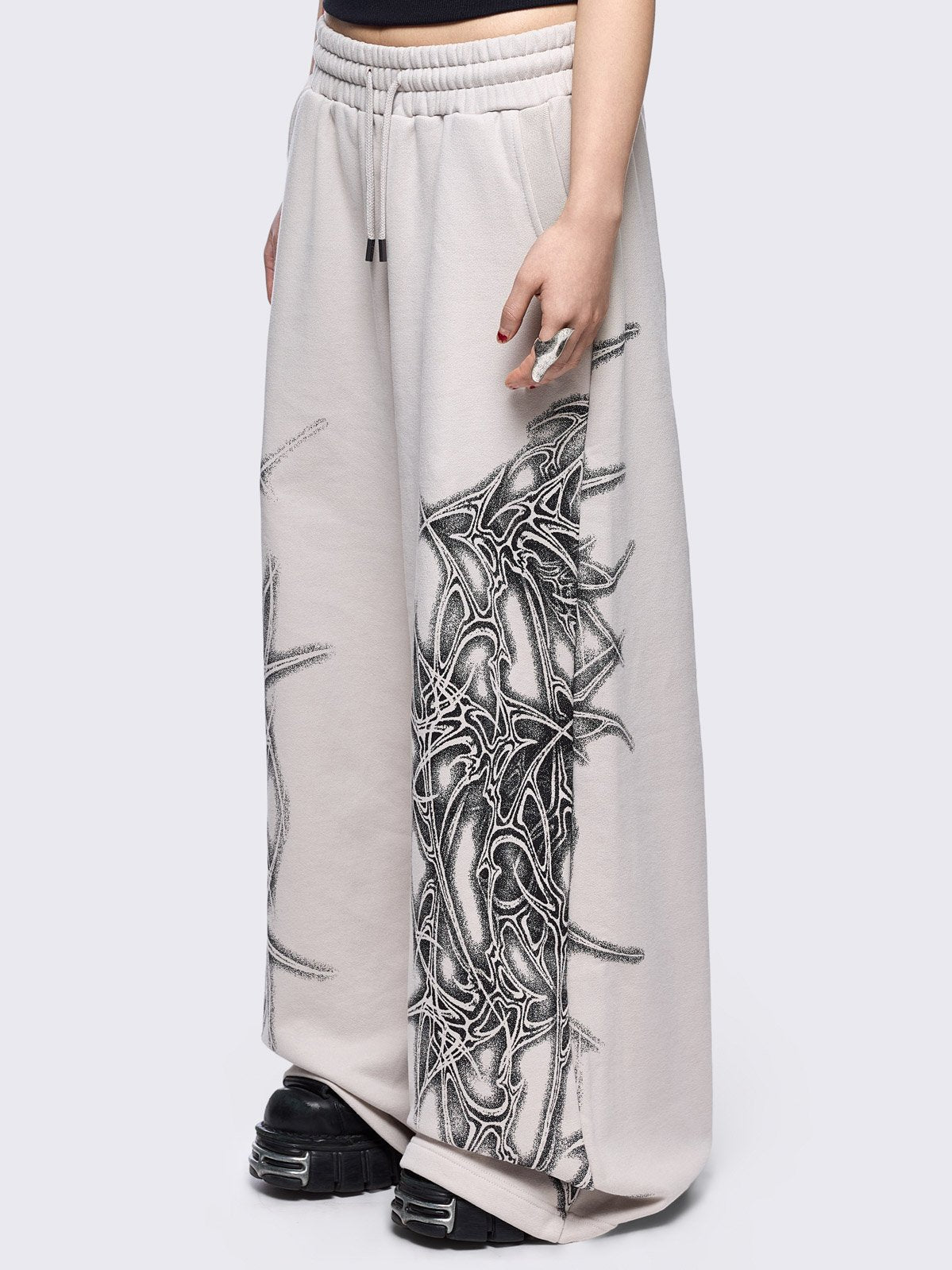 Grey wide leg sweatpants featuring a black sigilism graphic side print.