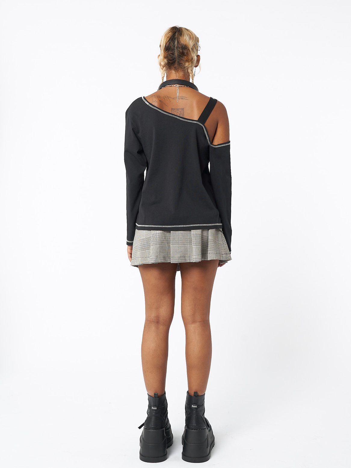 Asymmetric top in black featuring cut out shoulder with buckle grommet eyelet strap and Shocky girl graphic front print