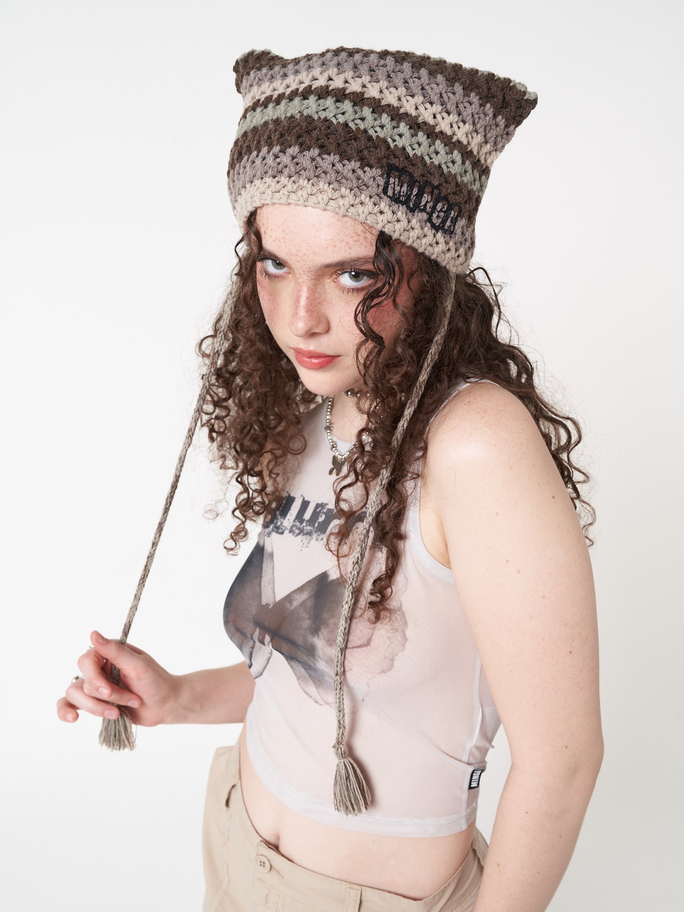 Knitted tie hat with all over stripes in green, brown and beige matching crochet style pattern and minga logo front embroidery