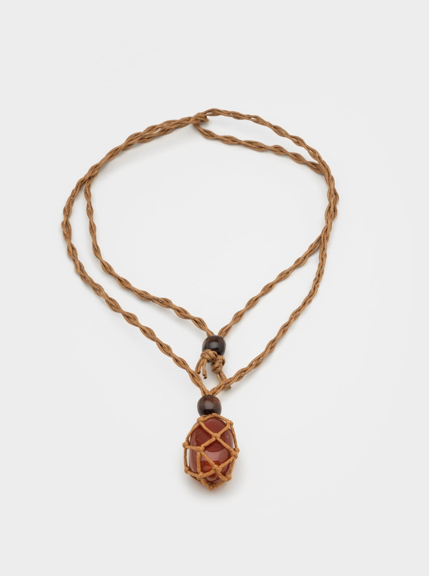 Necklace with cord chain and caged brown stone pendant