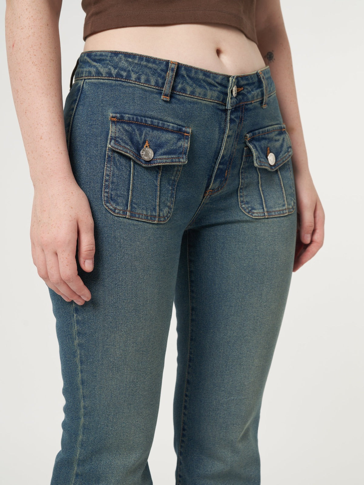 Low rise flare jeans with mini front pockets and vintage green overdye wash