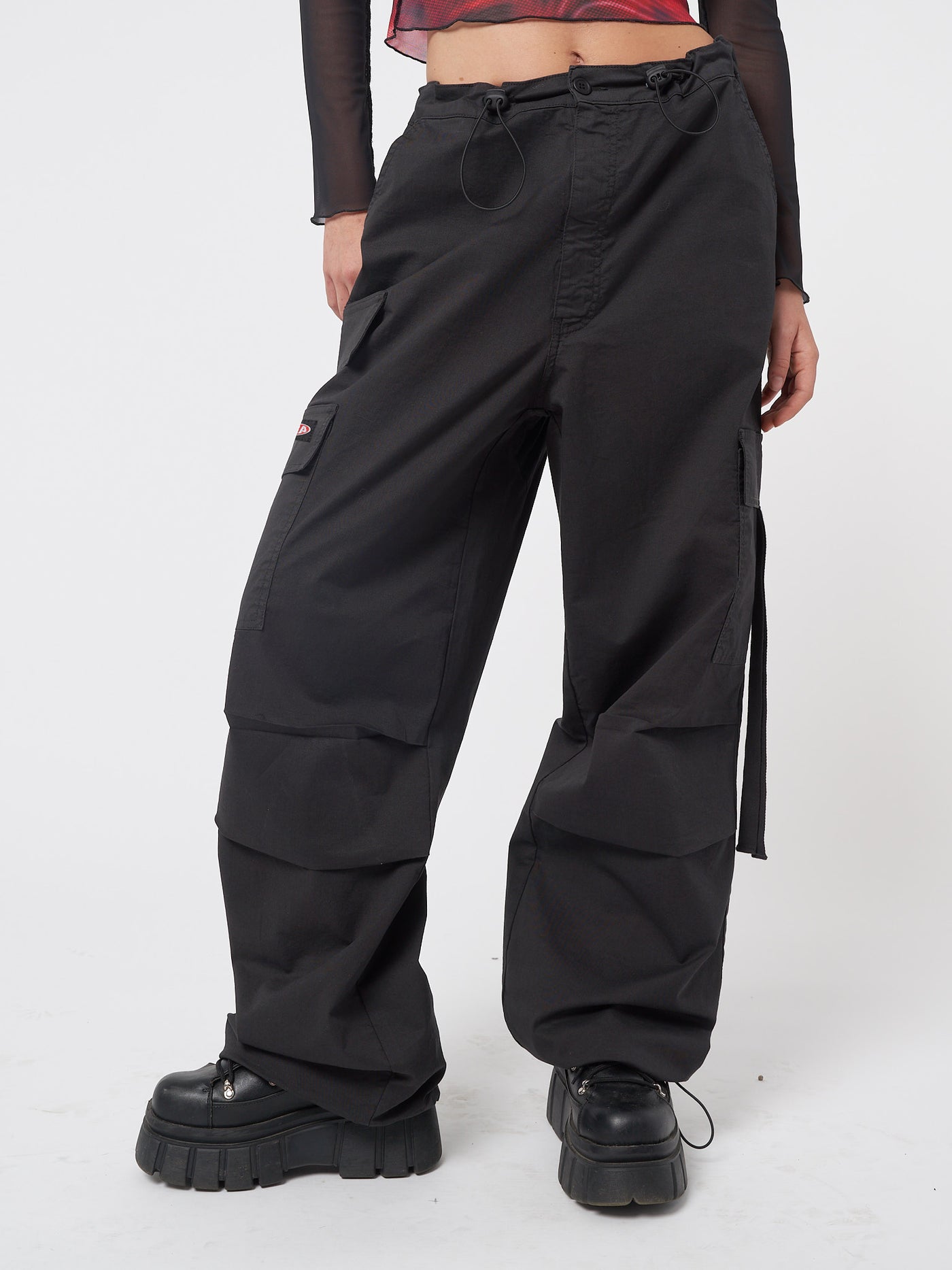 Black tech cargo pants in parachute style with side utility pockets 